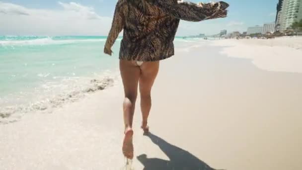 Жінка проходить уздовж прекрасного пляжу поруч з блакитною океанічною водою — стокове відео