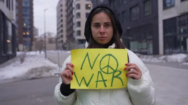 Silna kobieta stojąca w proteście trzymająca znak Nie ma wojny — Wideo stockowe