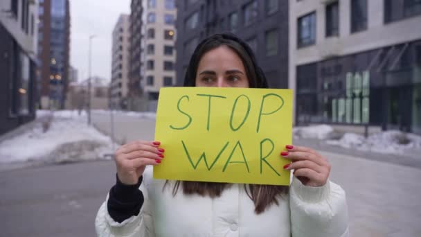 Mujer fuerte de pie en protesta sosteniendo un cartel para detener la guerra — Vídeos de Stock