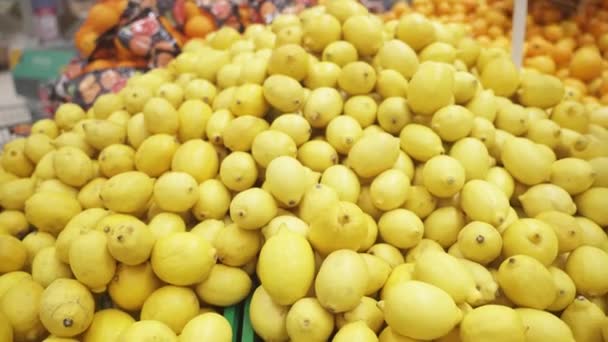 Limones amarillos en el mostrador de la tienda. Frutas maduras y sanas. — Vídeos de Stock