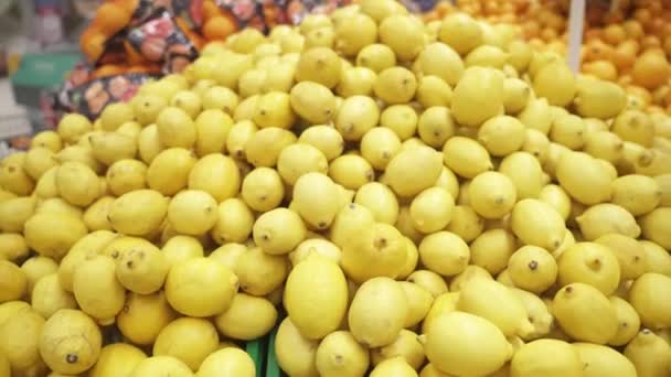 Cosecha de limón amarillo maduro. Muchos limones en el supermercado — Vídeos de Stock