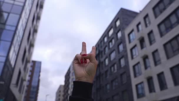 Femme levant deux doigts vers le haut et montrant la paix ou symbole de victoire ou lettre V. Femme une main tenant deux doigts vers le haut en langue des signes sur le fond de la ville. Pas de concept de guerre — Video