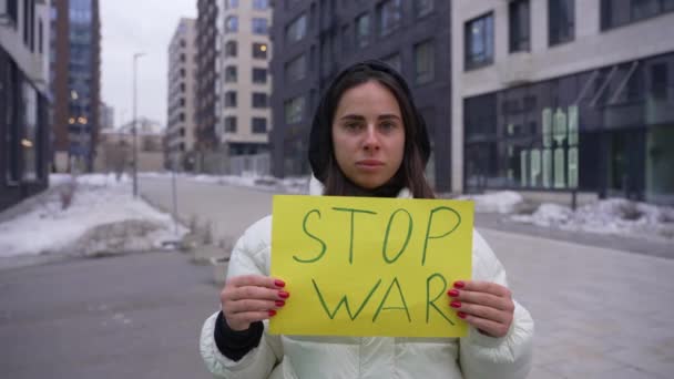 Starke Frau, die aus Protest ein Schild hält, das den Krieg stoppt — Stockvideo