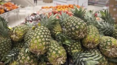 Süpermarkette tezgahın üzerinde taze ananaslar.