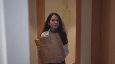 Genç bir bayan, Valencia, İspanya 'da bir apartmanın kapısından girerken kız arkadaşına sarılıp onu karşılar. - Orta boy yakın çekim.