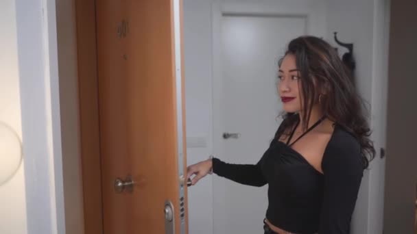 Mulher colombiana abre porta, acolhe e abraça seu amigo. tiro médio — Vídeo de Stock