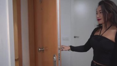 Siyah elbiseli bir kadın kapıyı açar ve Valencia, İspanya 'da Cadılar Bayramı tatilinde dairesinde arkadaşına tatlı bir sarılmayla hoş geldin der. - Orta boy.