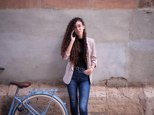 Жінка арабська дорослий стоїть поруч з велосипедом, що приймає телефонний дзвінок — стокове фото