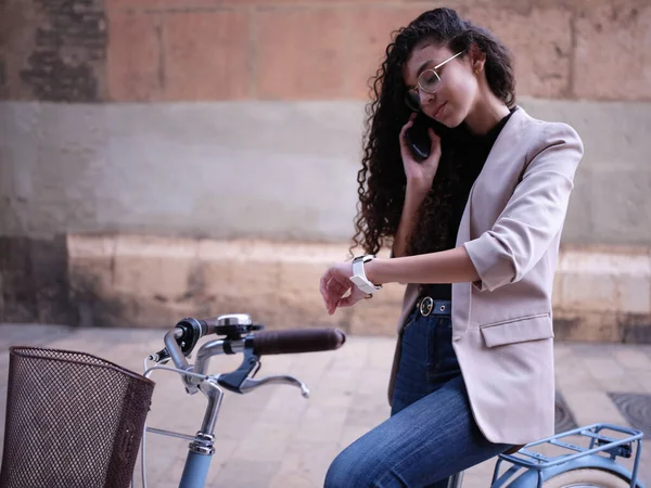 Mujer árabe sentada en una bicicleta se detuvo mientras hablaba por teléfono — Foto de Stock