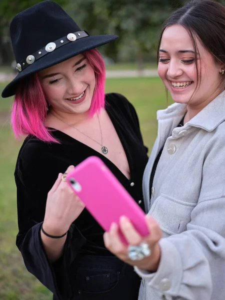 दोन तरुण महिला हसत असताना फोन स्वत: ची चित्रे घेऊन — स्टॉक फोटो, इमेज
