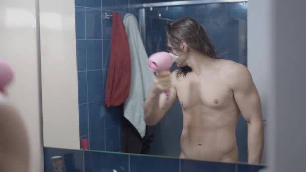 Volledig naakt metroseksuele man met behulp van een haardroger in de voorkant van de badkamer spiegel na een douche - Midden schot — Stockvideo