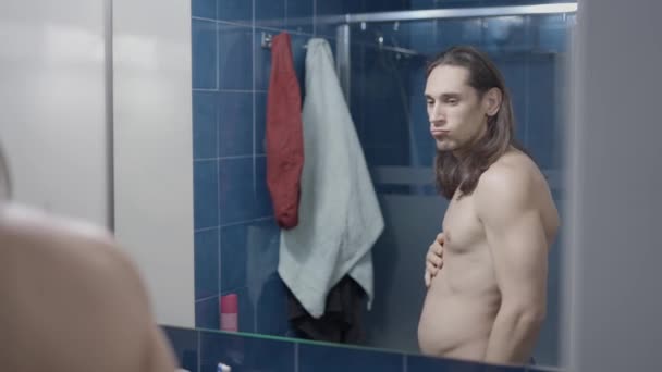 Jonge naakte man zuigen in zijn buik wensen om fitter te zijn - Midden schot — Stockvideo