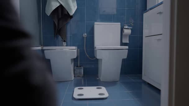 Man weighting himself in the bathroom as a morning routine - Close up shot — Vídeo de Stock
