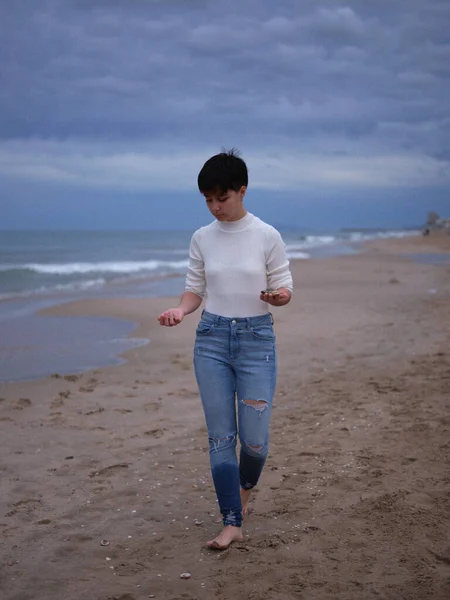 Transgender-Person läuft barfuß im Sand mit Muscheln in den Händen — Stockfoto