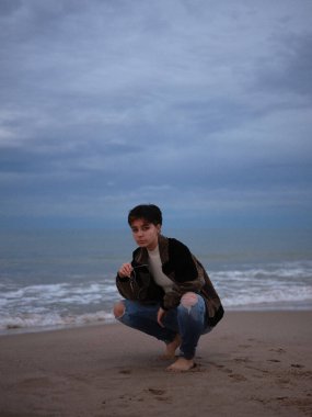 Cinsiyet değiştiren kadın elinde gözlüklerle kameraya bakıyor.