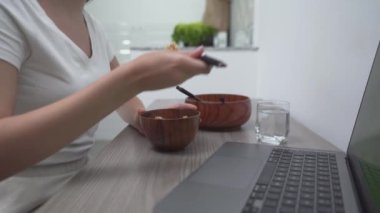 Diz üstü bilgisayarın yanında ahşap teçhizat ve kase kullanan biri. Yakın çekim.