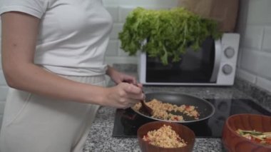 Mutfakta yemek pişirirken tatlı bayan yemekleri tadıyor. Ortalama atış, eğik atış