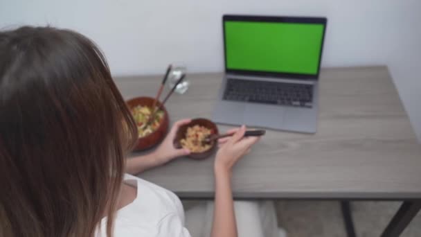 Overhead Shot de uma mulher comendo refeição de arroz enquanto na frente de seu laptop. — Vídeo de Stock