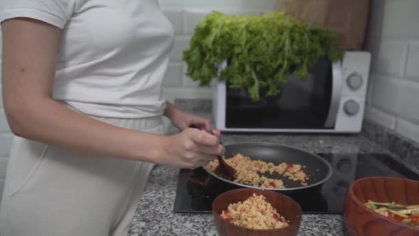 Encantadora dama degustación de alimentos mientras cocina en la cocina. plano medio, inclinación hacia arriba — Vídeos de Stock