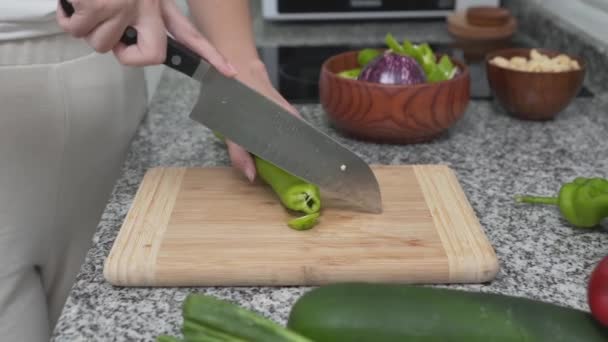Femei felii de mână ardei iute verde cu cuțit de bucătărie. - close up — Videoclip de stoc