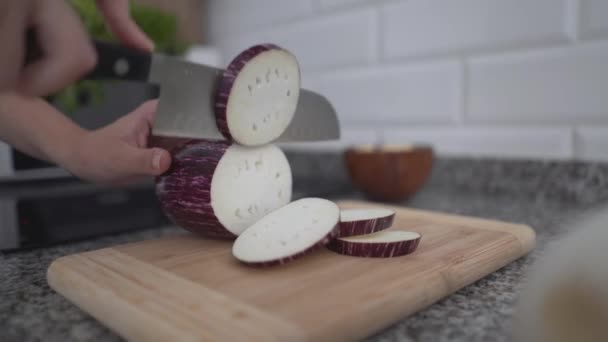 Woman Slicing Eggplant Into Circle On Chopping Board In The Kitchen. - close up — Stockvideo