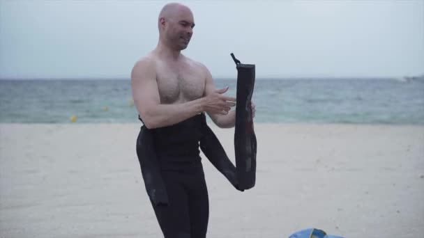 スペインのマヨルカ島のビーチでカイトサーフィンの準備をしているプロのカイトサーフィン。ミディアムショット — ストック動画