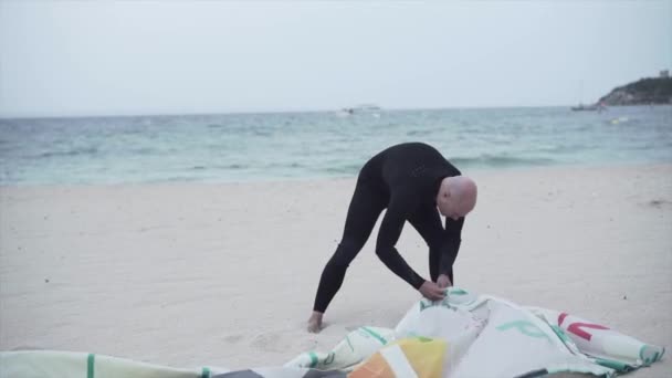 Man In Wetsuit is Setting-up His Power Kite For Kitesurfing In The Beach Of Mallorca Island, Espanha. Ampla — Vídeo de Stock
