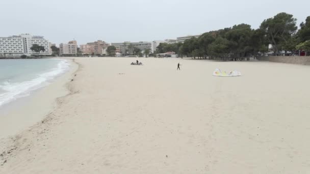 Kitesurfers Fixing His Power Kite On Palmanova Beach On A Rainy Day In Majorca Island, Spain. - aerial — стокове відео