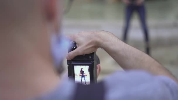 Fotógrafo profesional con cámara réflex digital tomando fotos de una joven marroquí en la ciudad. de cerca — Vídeos de Stock