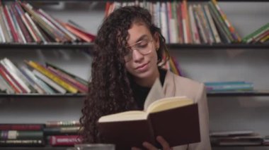 Moroccan Young Woman Smiling And Enjoys Reading Book During Her Free Time. - close up