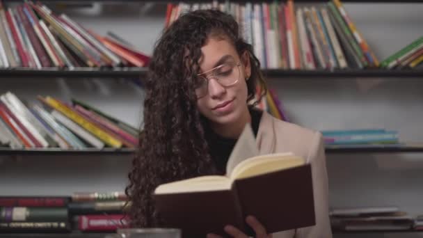 Moroccan Young Woman Smiling And Enjoys Reading Book During Her Free Time. - close up — Stok video