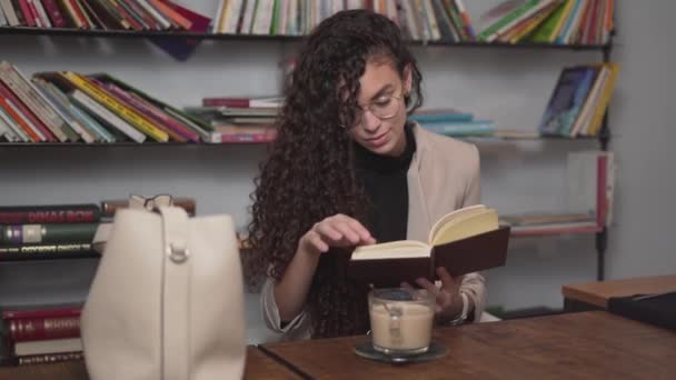 Beautiful Moroccan Businesswoman enjoying a good read in the library — Stock videók