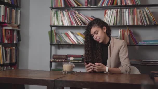 Young Businesswoman Calls Someone On Her Mobile Phone While Having Coffee Break In The Office. medium shot — Vídeo de Stock