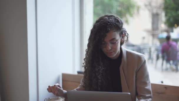 Moroccan Woman At Cafeteria Stirring Coffee While Looking At Laptop Computer. - close up — Vídeo de Stock