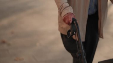 Yaşlıların el ele tutuşup yürüteçleri itmelerine yakın çekim