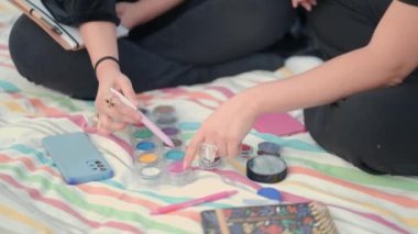female hands choose color tone in makeup palette. Close up view . fashion market, cosmetics