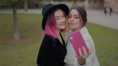 close up view on attractive young women smiling as taking selfies photos with cell phone
