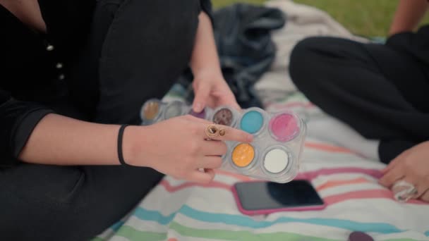 Zblízka na dívky ruka ukazuje na růžovou barvu v make-up paletě — Stock video