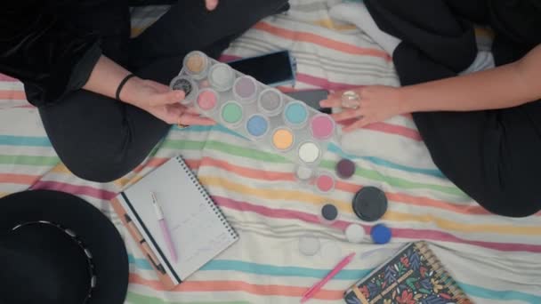 Γυναικεία χέρια που δείχνουν και επιλέγουν χρώματα στην παλέτα μακιγιάζ. Εναέρια βολή — Αρχείο Βίντεο