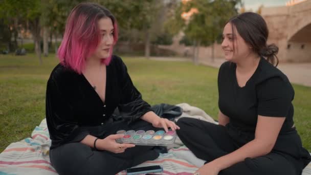 Pink and brown haired girls chatting and laughing at the park. medium close up — Vídeo de Stock