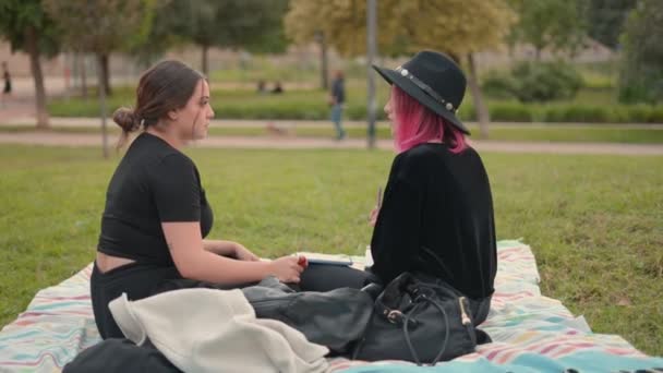Women spending leisure time and chatting while sitting at city park. push in slomo shot — Wideo stockowe