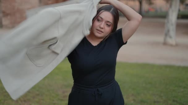 Young charming brunette girl wearing black clothes and putting on stylish jacket, slowmotion — 图库视频影像