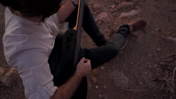 Jeune guitariste masculin hipster en plein air jouant de la guitare vue de dessus gros plan inspiré au coucher du soleil — Video