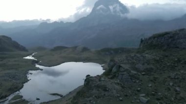 Günbatımından sonra Fransa 'daki Pireneler' de sonbahar mevsiminde Ayous Gölü 'nün çekilen su seviyesini kuşların gözleri görür.