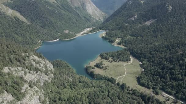 Vacker antenn utsikt framåt skott över sjön Ayous med grön skog på alla sidor på en bergig terräng i Pyrenéerna i Frankrike. — Stockvideo