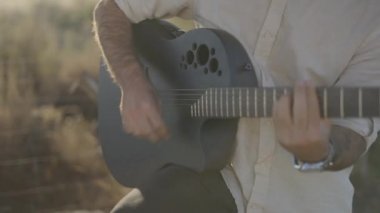 Mans Hands Sunset 'te Siyah Akustik Ovation Gitar Çalıyor - yakın çekim, yavaş çekim