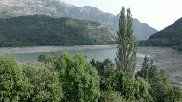 Flygfoto vidarebefordran skott från över skogen omger de allvarligt vikande vattennivåerna i sjön Ayous under höstsäsongen på grund av den globala uppvärmningen i Pyrenéerna i Frankrike. — Stockvideo