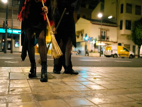 Ноги двух молодых женщин, одетых в костюмы ведьм для Хэллоуина на улицах Валенсии, Испания. — стоковое фото
