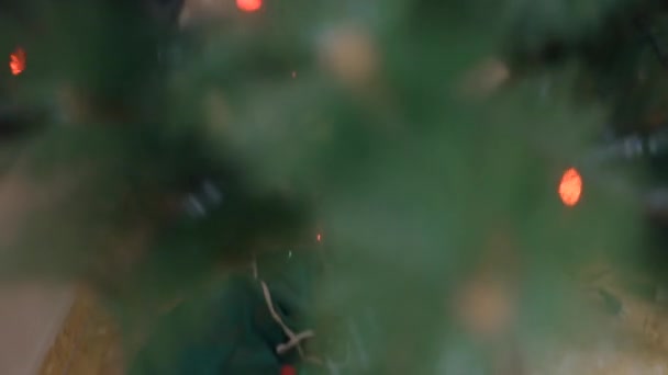 Mooie kerstboom vol met versieringen en gloeiende touwverlichting. Tracking Shot — Stockvideo