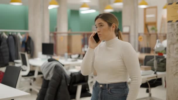 Kontorsarbetare som står i arbetsrummet och pratar i telefon med oroliga ansiktsuttryck — Stockvideo